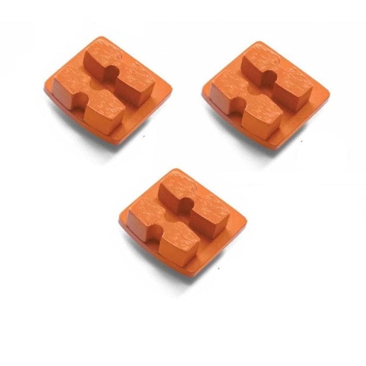 Three orange Husqvarna single-segment diamond grinding tools with rectangular bases and grooved pads; designed for hard concrete surface prep.