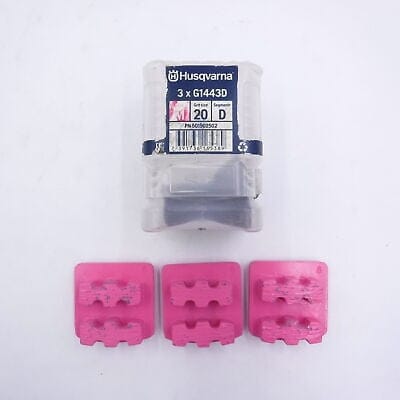 Three pink Husqvarna G1443D diamond grinding segments placed in front of labeled container; marked “Grit: 20 Segment: D PN: 506909502”.