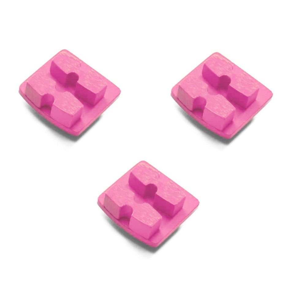 Three pink Husqvarna double-segment diamond grinding tools with H-shaped raised pads on rectangular bases; designed for coating and concrete removal.