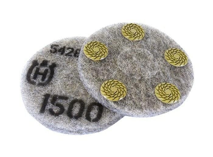 Circular Husqvarna polishing pads shown front and back; one displays printed grit rating and branding, the other reveals four yellow abrasive segments arranged in a circular pattern. Designed for dry concrete polishing with planetary and edge grinders.