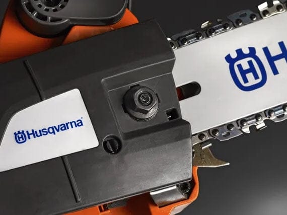 Close-up overhead view of the Husqvarna 535i XP chainsaw's side cover featuring a retained bar nut and a portion of the 14-inch guide bar and saw chain.