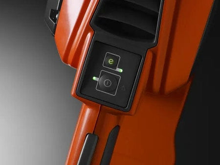 Detailed view of the intuitive keypad on a Husqvarna chainsaw showing the power button and the green savE mode button with active LED indicator lights.