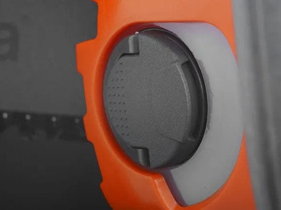 Close-up view of the flip-up tank cap on the Husqvarna 535i XP chainsaw, designed for easy opening and closing even when wearing heavy work gloves.