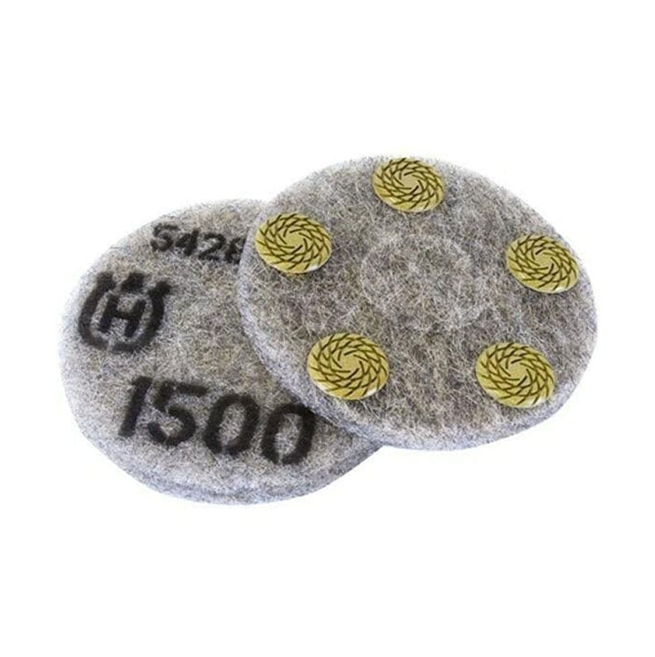 Circular Husqvarna polishing pads shown front and back; one displays printed grit rating and branding, the other reveals four yellow abrasive segments arranged in a circular pattern. Designed for dry concrete polishing with planetary and edge grinders.