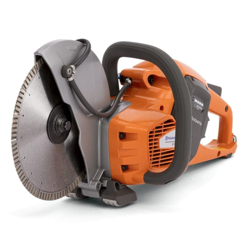 Angled view of the Husqvarna K535i cordless cut-off saw with a diamond blade, emphasizing the compact, balanced design. The water feed tubes are visible on the gray blade guard.