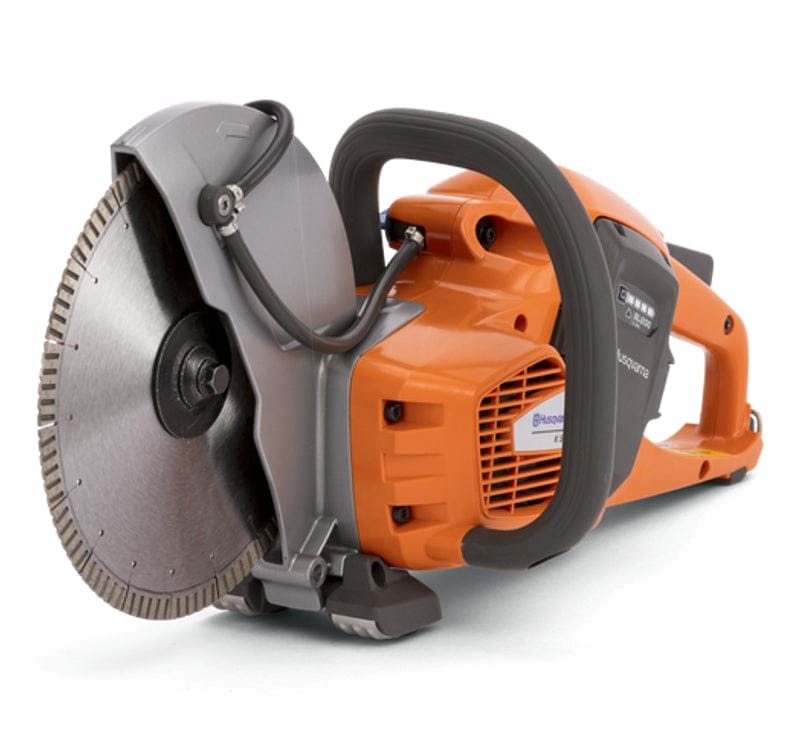 Angled view of the Husqvarna K535i cordless cut-off saw with a diamond blade, emphasizing the compact, balanced design. The water feed tubes are visible on the gray blade guard.