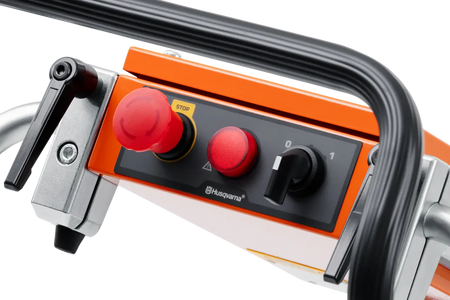 Close-up of the Husqvarna PG 450 control panel, featuring the emergency stop button, power indicator light, and simplified on-off switch for intuitive machine operation.