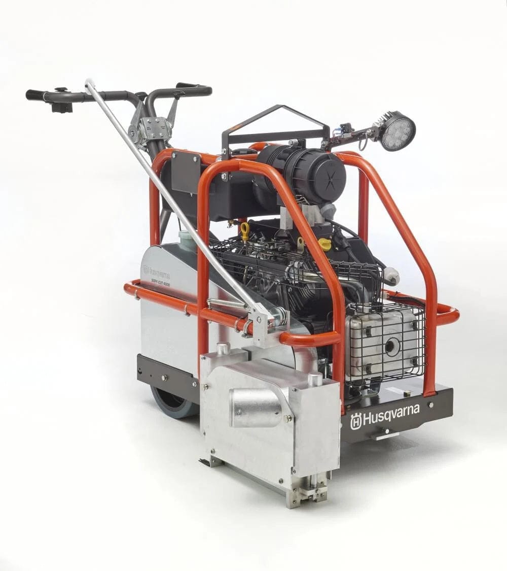 A studio product shot of the Husqvarna Soff-Cut 4000 self-propelled saw against a white background, featuring a robust orange roll cage, silver protective paneling, and a large black canister air filter.