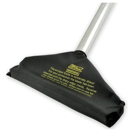 Close-up of the floor scraper head enclosed in a black nylon safety cover. Yellow printed text on the cover reads "WARNING The scraper blade is extremely sharp! For your protection the blade has been inserted with the sharp edge inside."