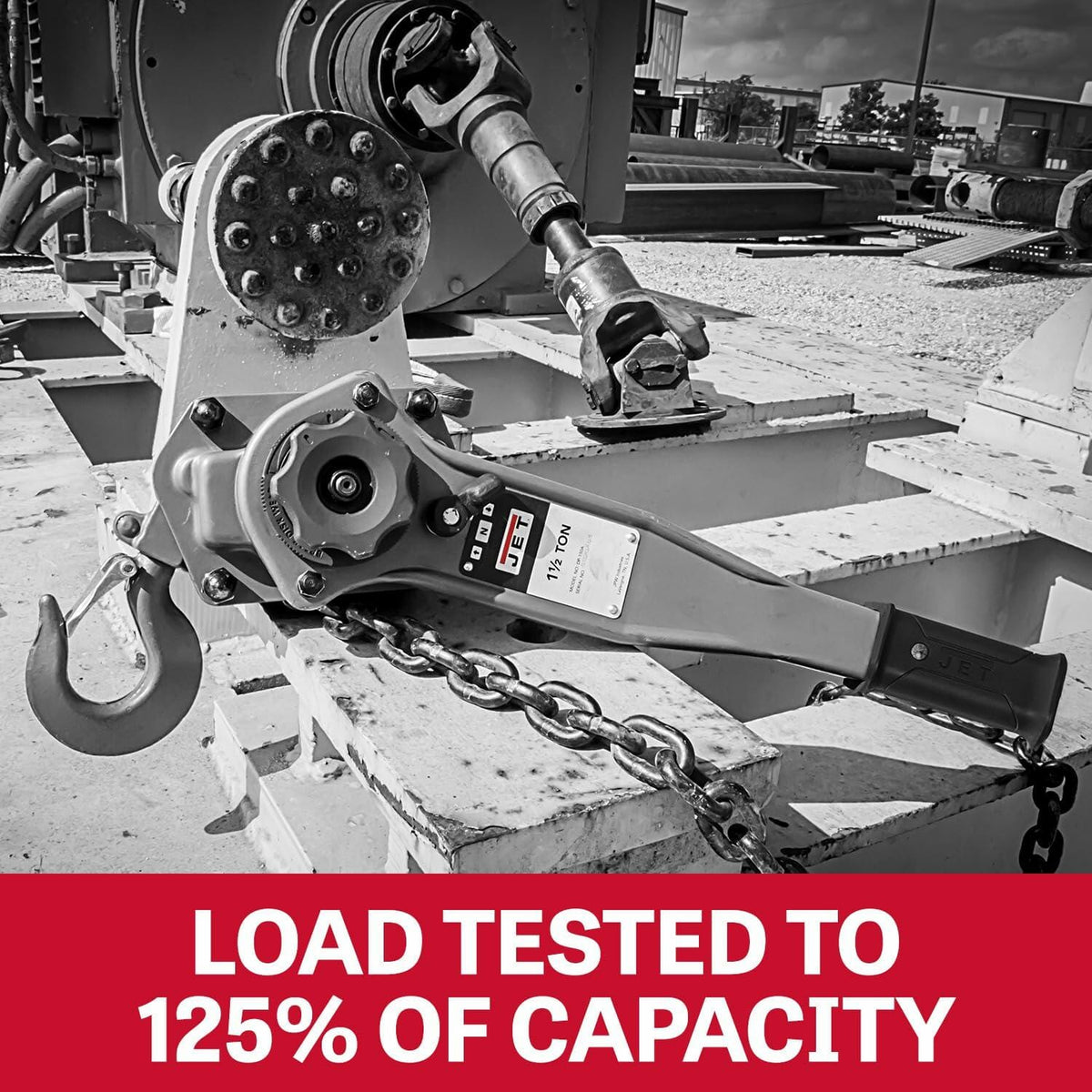 JET lever hoist mounted on metal structure with visible chain and hook, labeled "LOAD TESTED TO 125% OF CAPACITY" for safety assurance in industrial use.