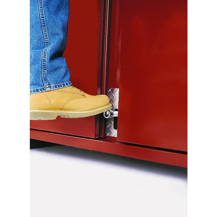 Person wearing work boots activates a foot-operated latch at the base of a red JOBOX cabinet door, demonstrating hands-free access.