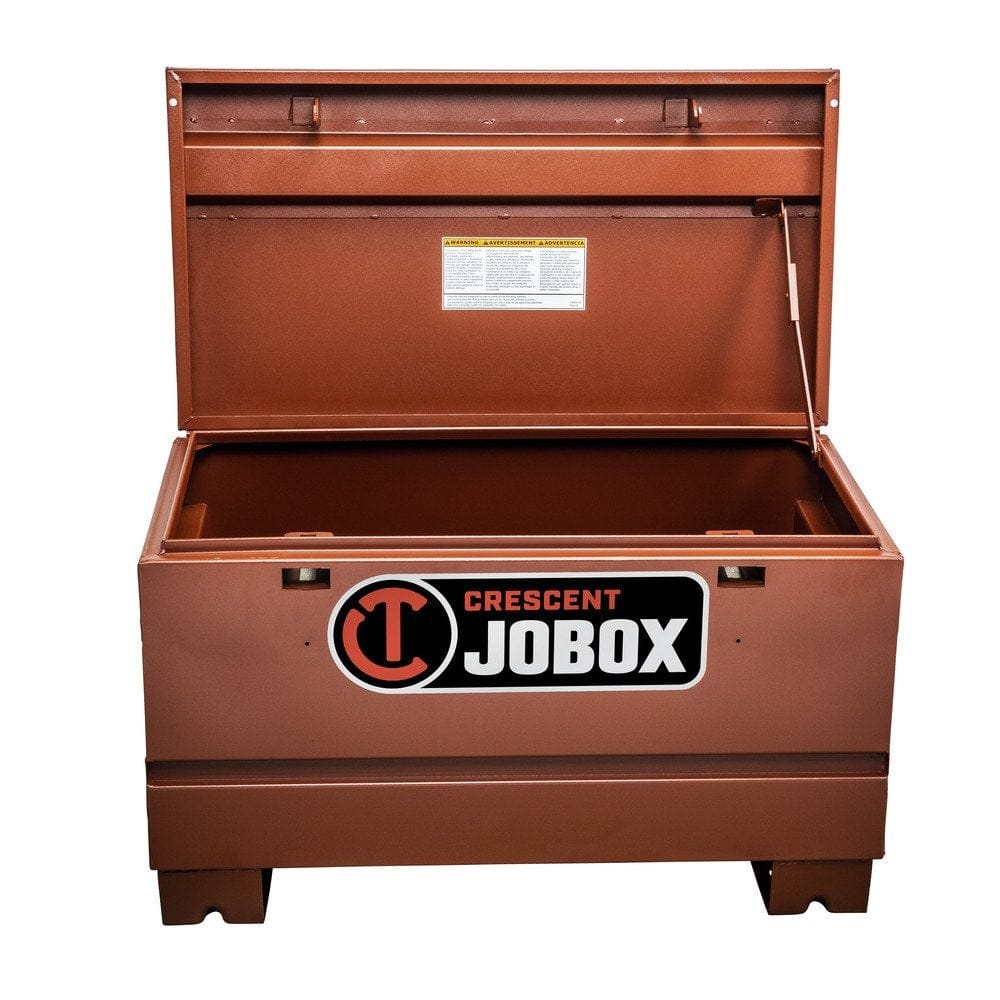 A three-quarter front view of the brown Crescent JOBOX 36-inch Tradesman steel jobsite chest with its lid fully open, showing the empty interior and the lid's warning label.