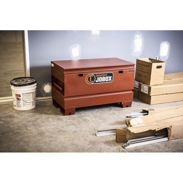 A front-facing view of the brown Crescent JOBOX 36-inch Tradesman steel jobsite chest, closed, showcasing the JOBOX logo and the enclosed dual lock system.