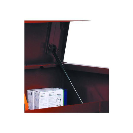 Interior of a Jobox storage chest showing a gas strut mechanism supporting the open lid. A box of electrical outlets is stored inside, demonstrating the chest’s capacity for organizing tools and hardware