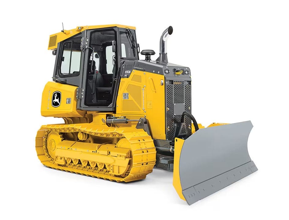 John Deere 650K crawler dozer in yellow and black with enclosed cab and large front blade, positioned on tracks for earthmoving at a construction site.