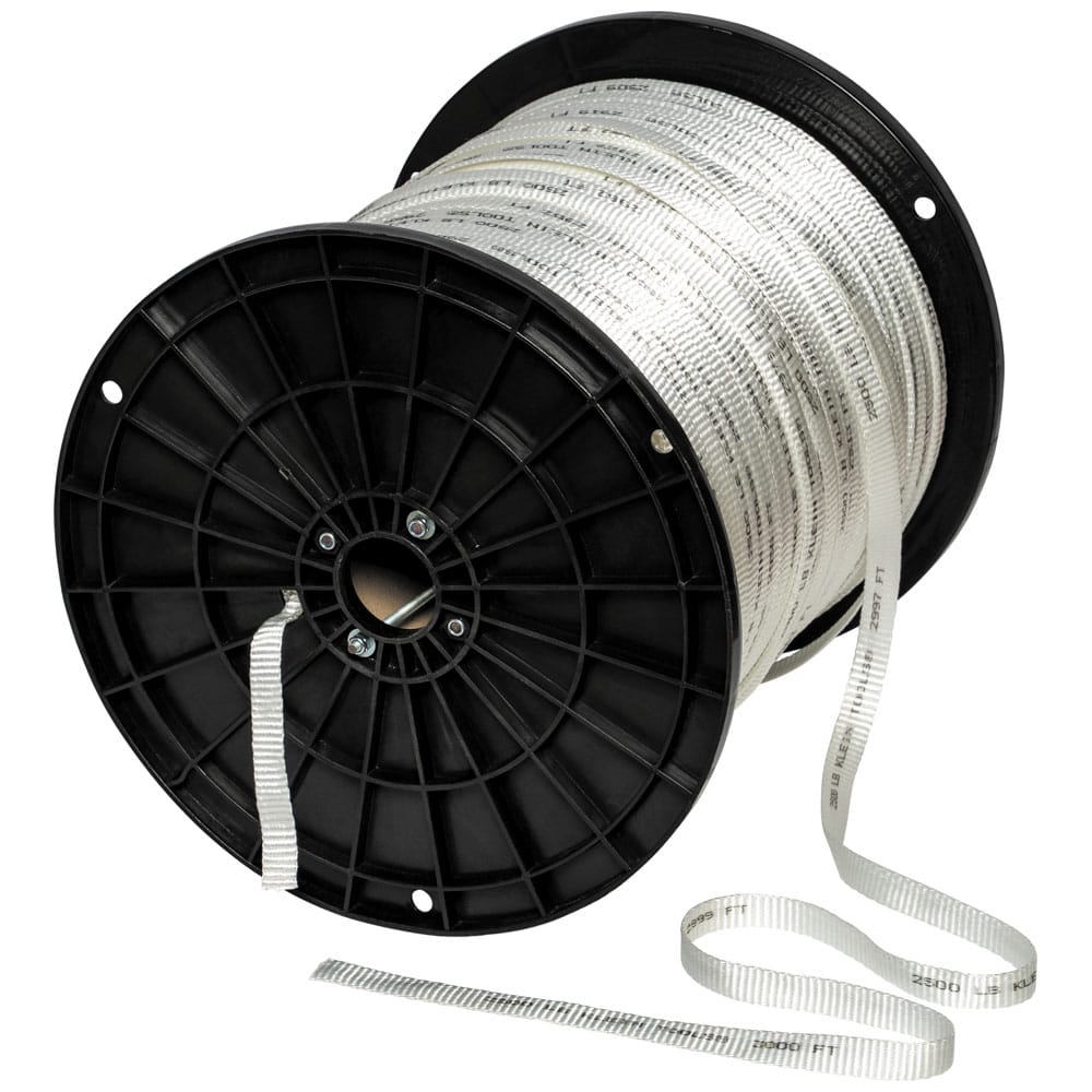 Klein Tools 50142 3000-foot pull tape reel leaning on its side showing the rod-reinforced spool and loose pre-lubricated line end.