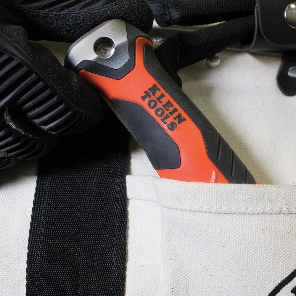 The Klein folding jab saw is shown folded and tucked into the pocket of a canvas tool bag.