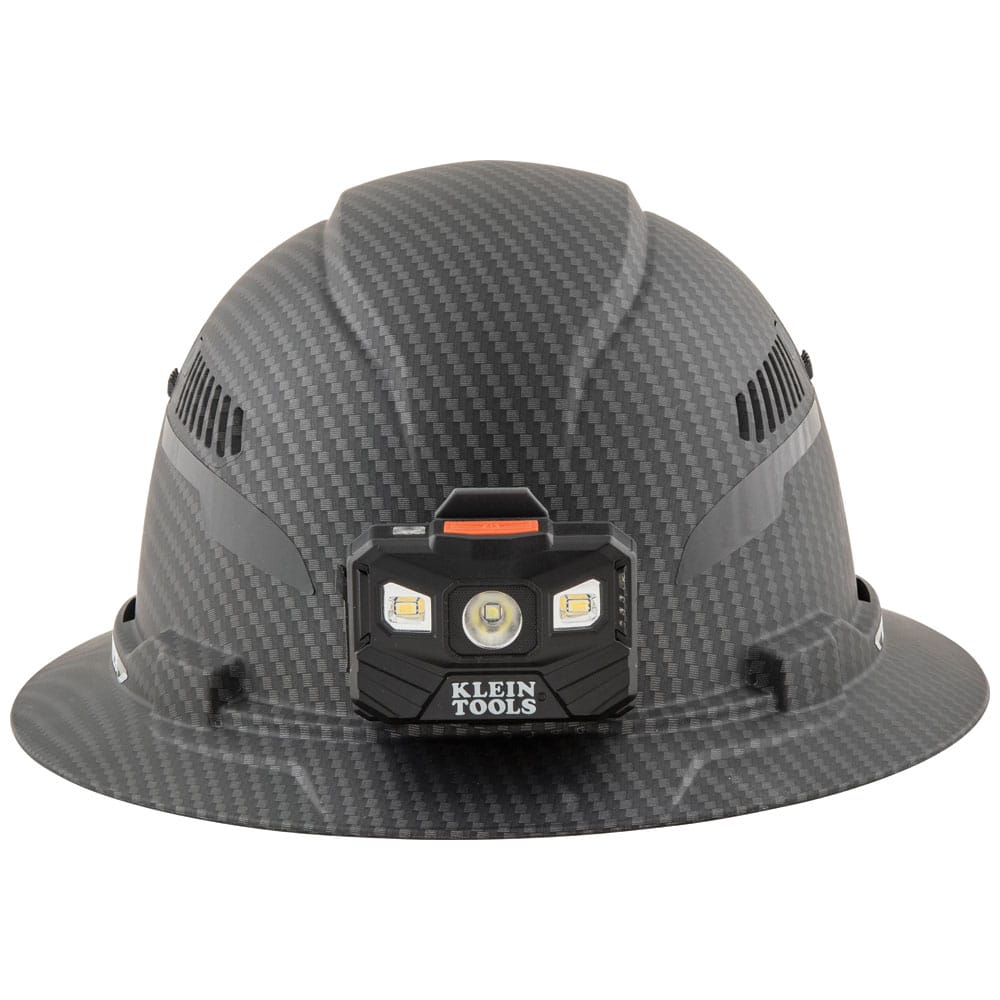 Front view of Klein Tools KARBN vented hard hat with attached 400-lumen LED headlamp providing hands-free work illumination.
