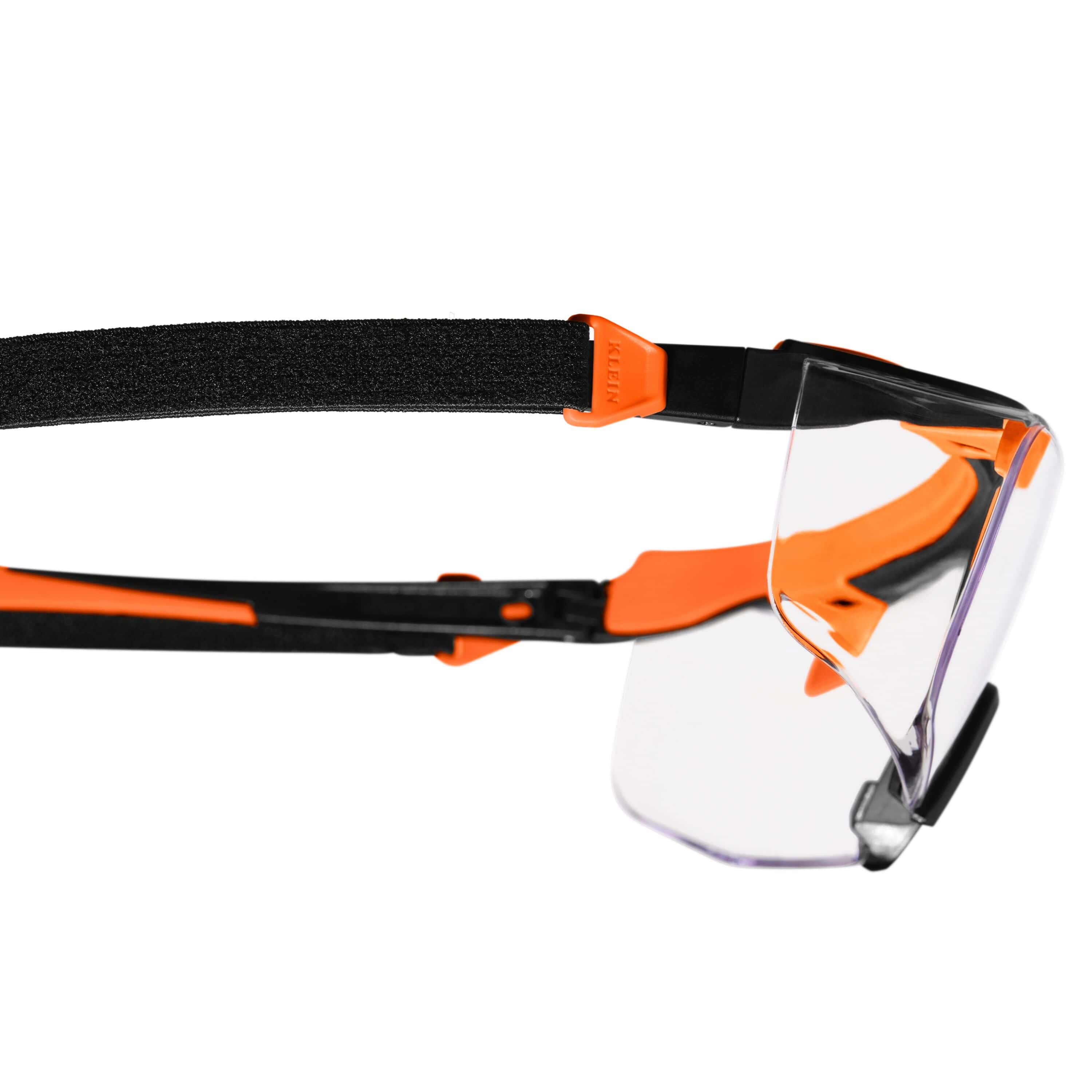 Close-up side profile of the eyewear highlighting the integrated attachment point for the removable strap on the orange and black nylon stems.