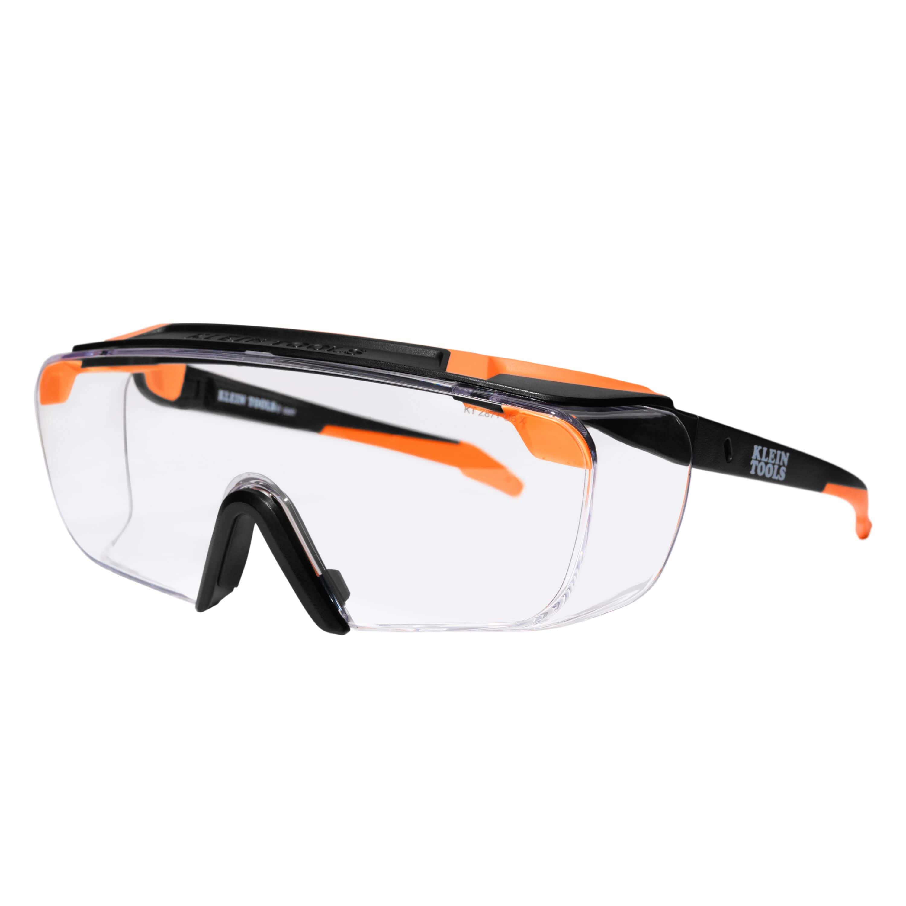 Flat lay perspective of the Klein Tools clear lens safety glasses, emphasizing the lightweight semi-frame construction and wide field of vision for industrial and construction environments.