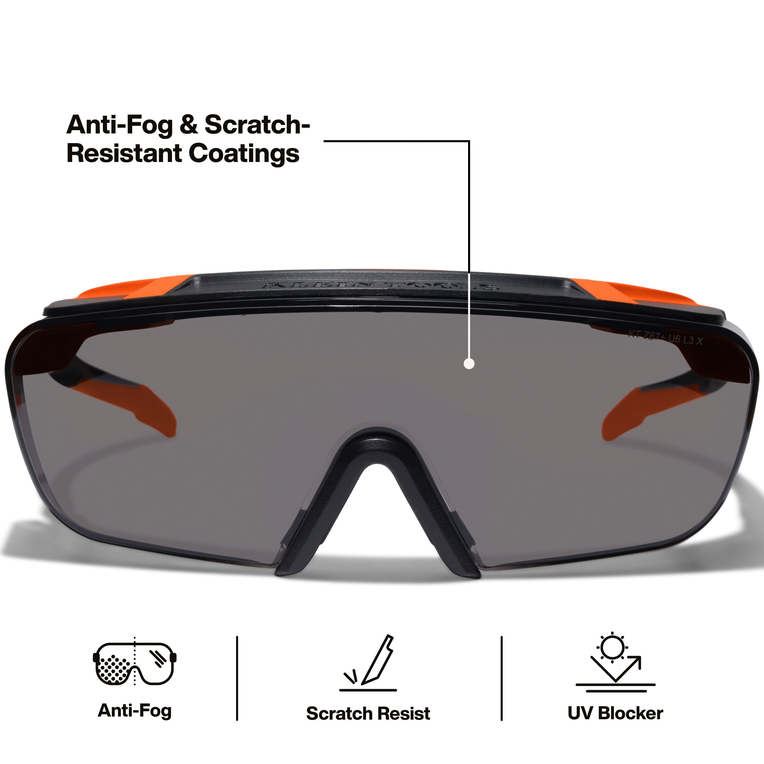 Full front view of the gray shaded safety glasses highlighting the premium anti-fog and scratch-resistant coatings, along with icons for UV protection and high-impact resistance standards.