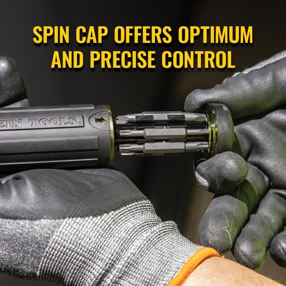 Close-up of a gloved hand holding the screwdriver handle and pulling out the bit storage cartridge, with text stating Spin Cap offers optimum and precise control.