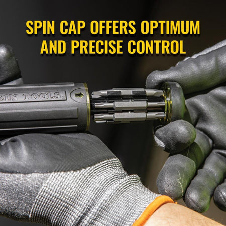 Close-up of a gloved hand holding the screwdriver handle and pulling out the bit storage cartridge, with text stating Spin Cap offers optimum and precise control.