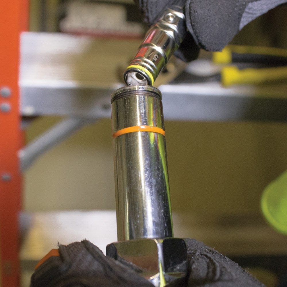 A close-up action shot of a professional wearing work gloves exchanging the color-coded bits on the Klein 32807MAG 7-in-1 nut driver to quickly adapt to a different hex fastener size.