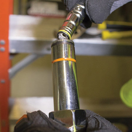 A close-up action shot of a professional wearing work gloves exchanging the color-coded bits on the Klein 32807MAG 7-in-1 nut driver to quickly adapt to a different hex fastener size.