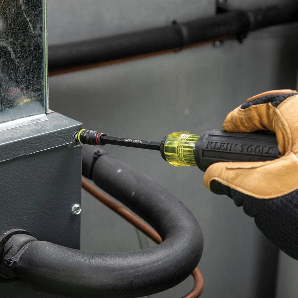 Action shot of a professional using the 7-in-1 flip socket set with a manual handle to tighten a hex screw on the exterior of a metal HVAC unit.