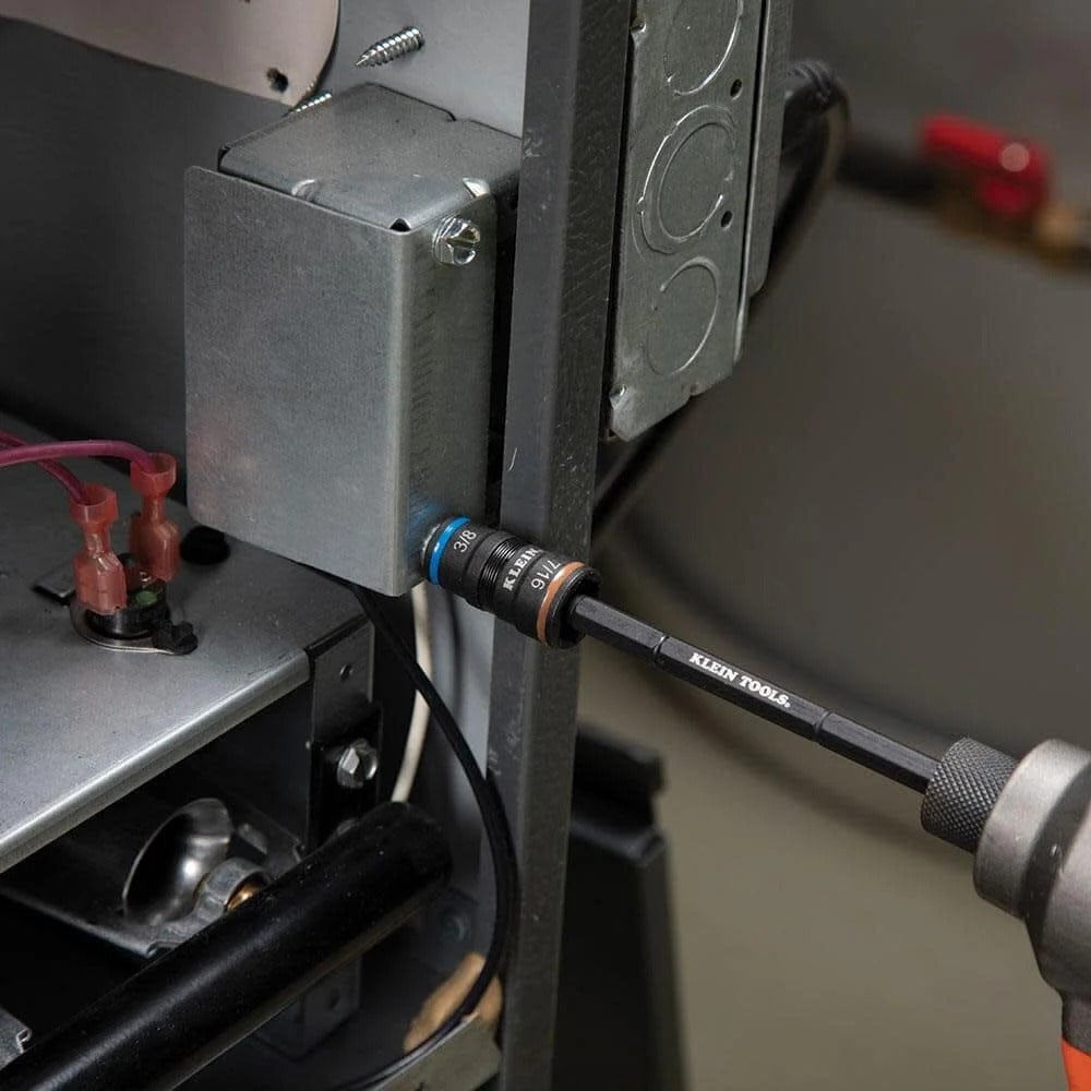 A close-up action shot showing the impact flip socket set being used with a cordless impact driver to fasten a hex screw on a metal electrical box inside a mechanical unit.