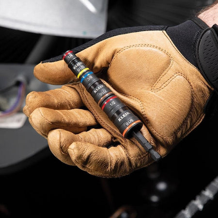 A person wearing a tan and black work glove holds the complete 7-in-1 impact socket set in their palm, illustrating its compact and portable design.