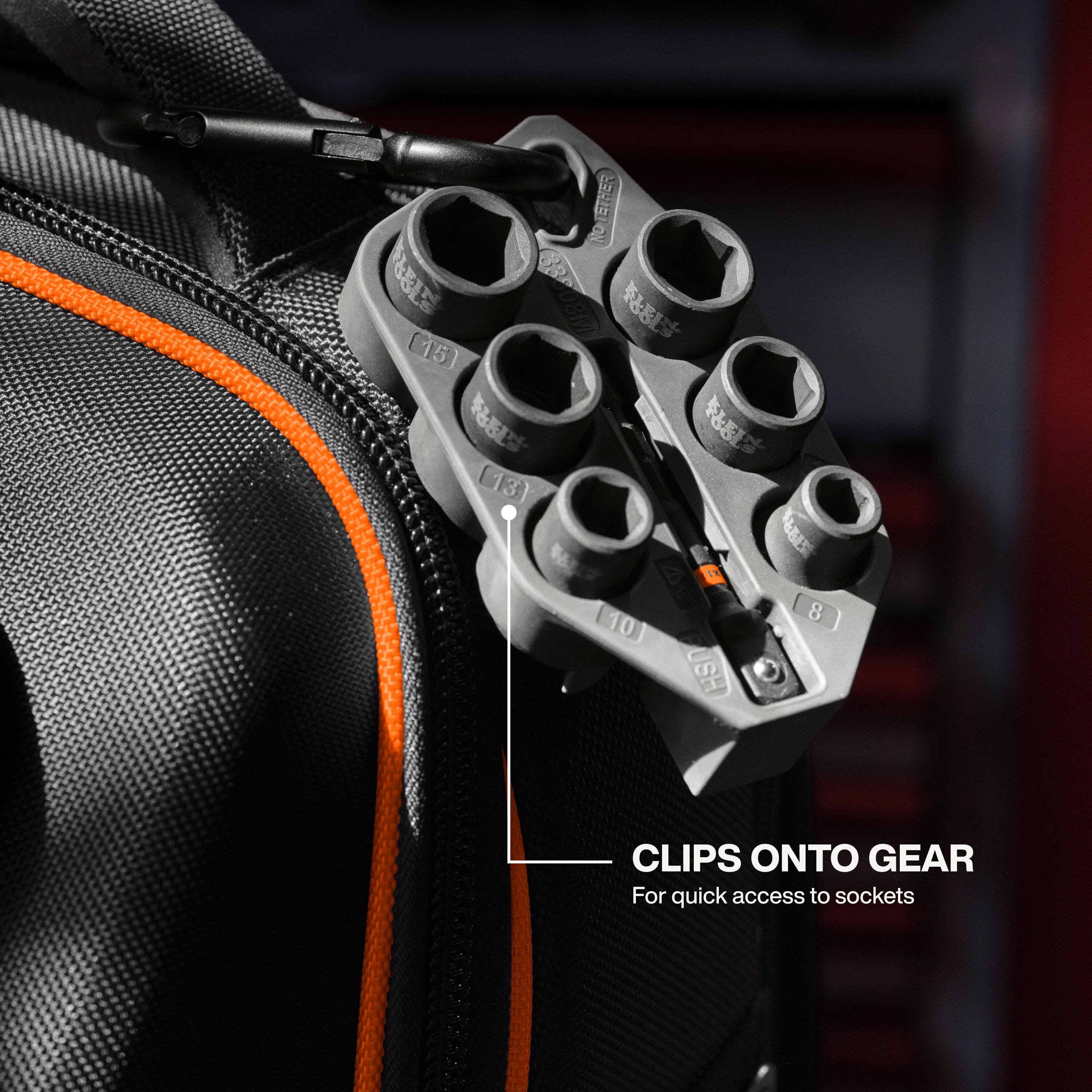An in-use application shot showing the Klein Tools Grab-And-Go socket sleeve clipped onto the side of a black job site backpack using the carabiner, demonstrating quick access to the metric sockets for increased job site productivity.