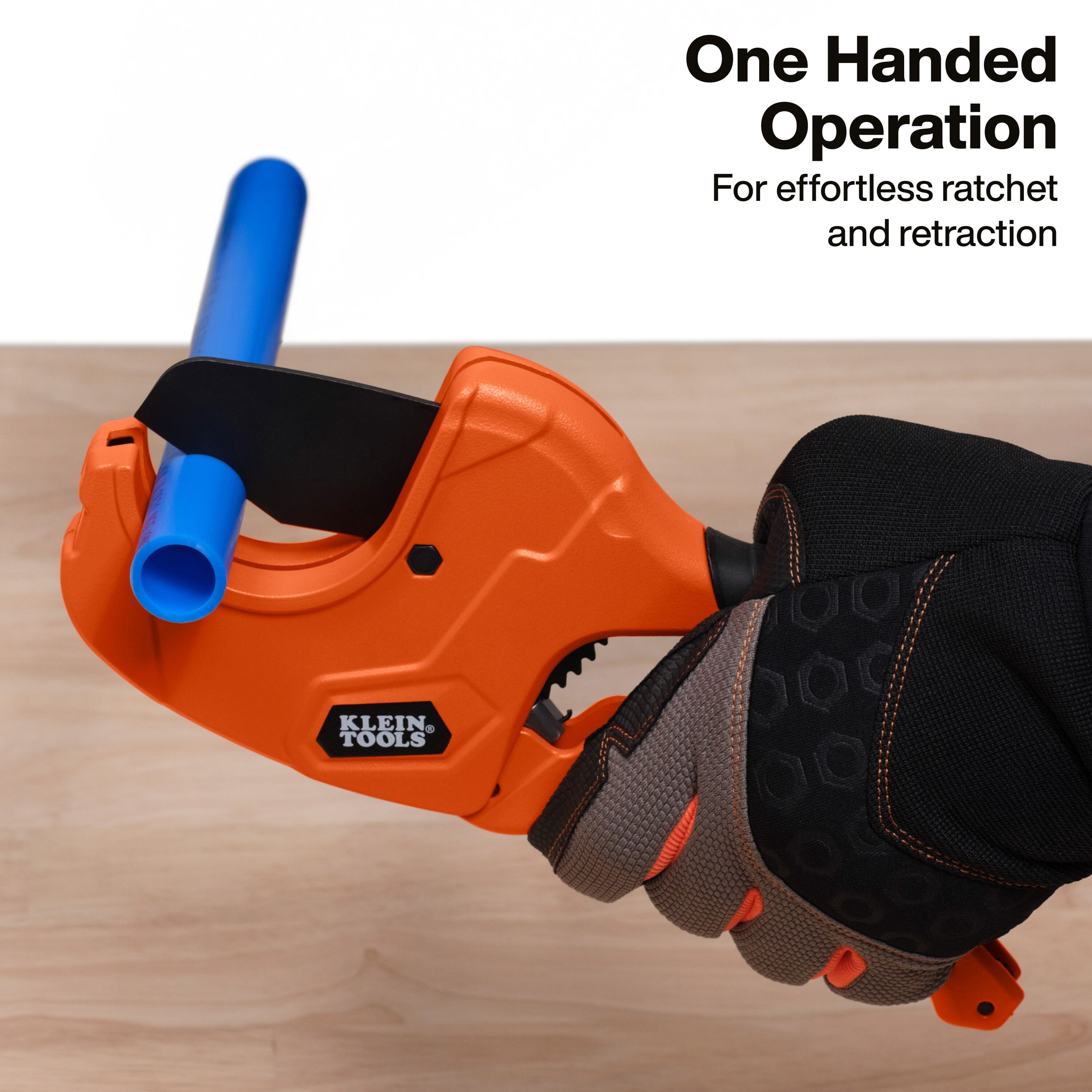 An informative graphic titled One Handed Operation for effortless ratchet and retraction, displaying a close-up field view of an operator wearing high-dexterity black and brown work gloves squeezing the heavy-duty orange handle loop to execute a smooth cutting stroke through a bright blue plastic PEX pipe line.