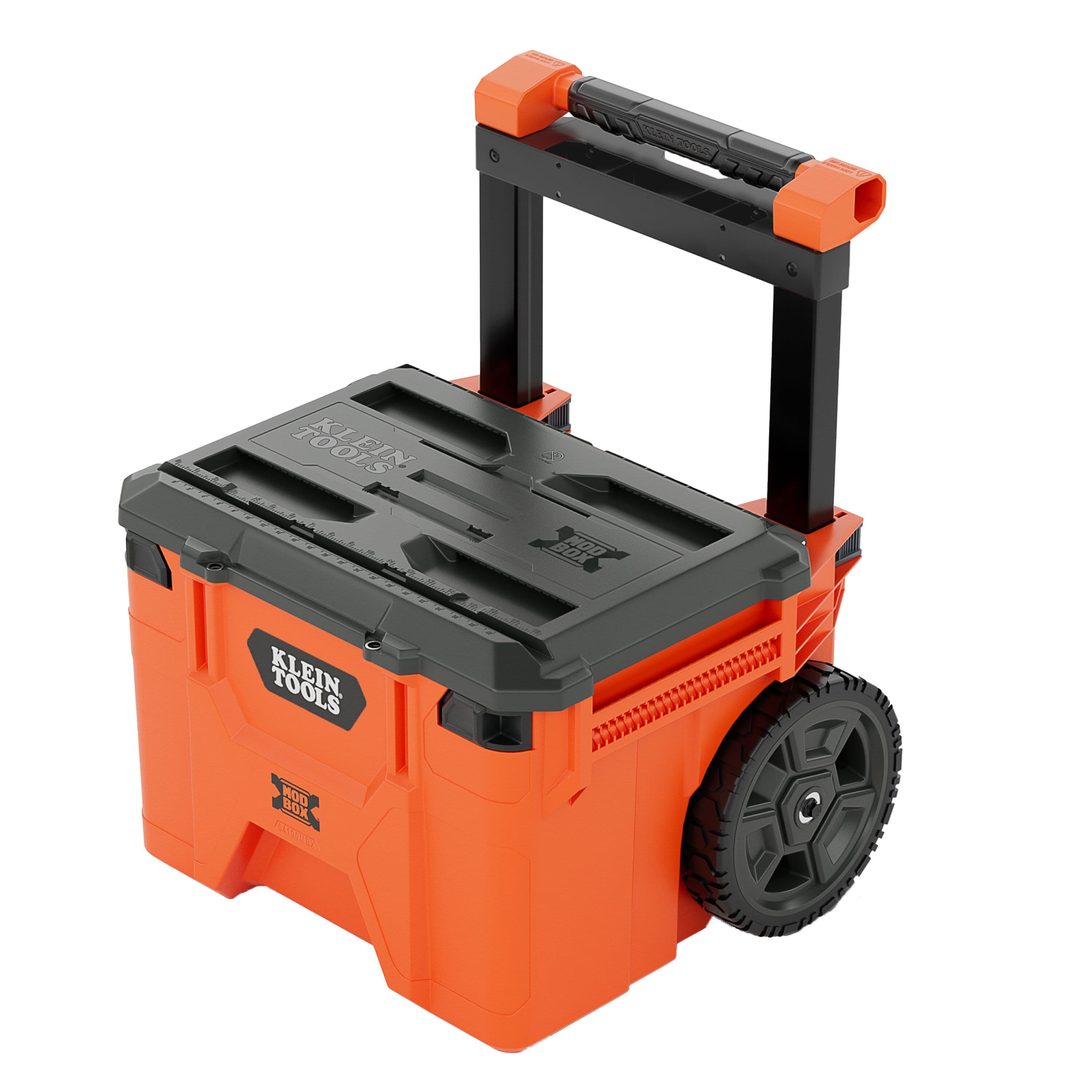 Perspective view of the Klein Tools 54100MBX MODbox rolling toolbox in iconic orange and black featuring a reinforced lid with ruler and V-groove, large 10-inch rubber wheels, and a telescoping handle.
