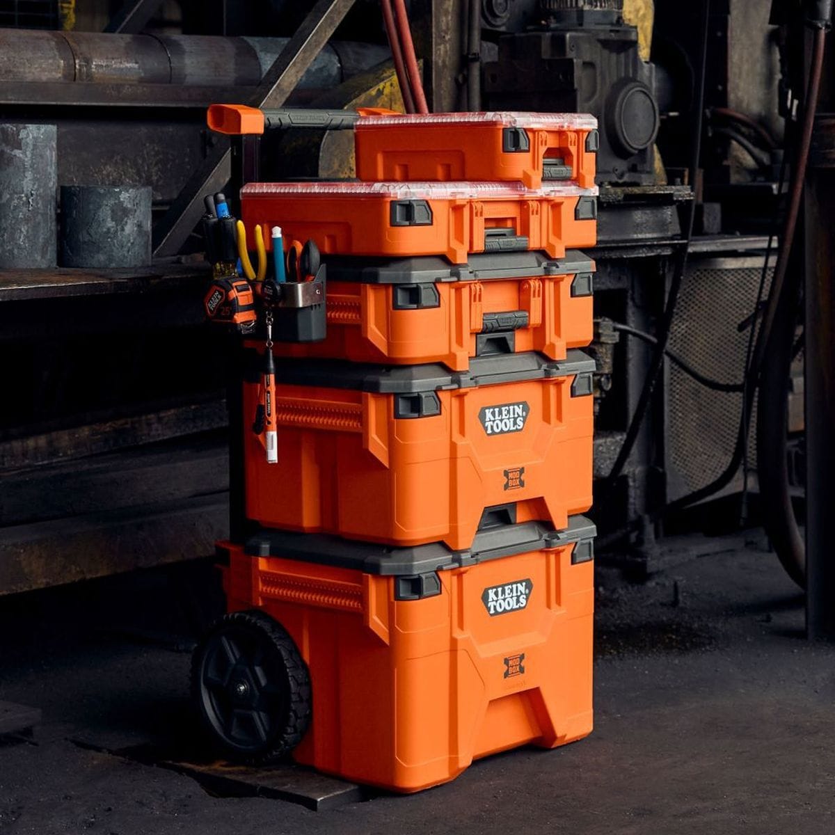 Action shot of a complete Klein Tools MODbox modular stack in a workshop setting, showcasing the half-width component box connected at the top for quick-access parts organization.