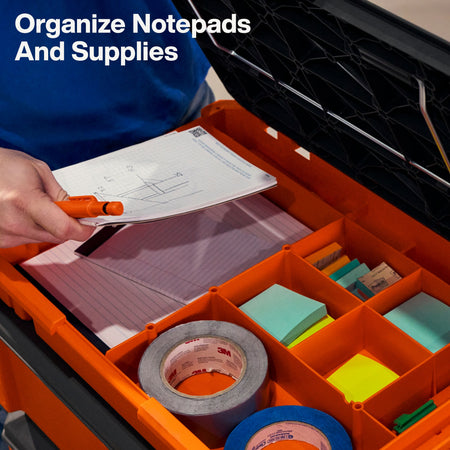 Interior view of the open work top tray showing organized notepads, pens, tape, and office supplies inside the specialized storage cubbies for jobsite administration.
