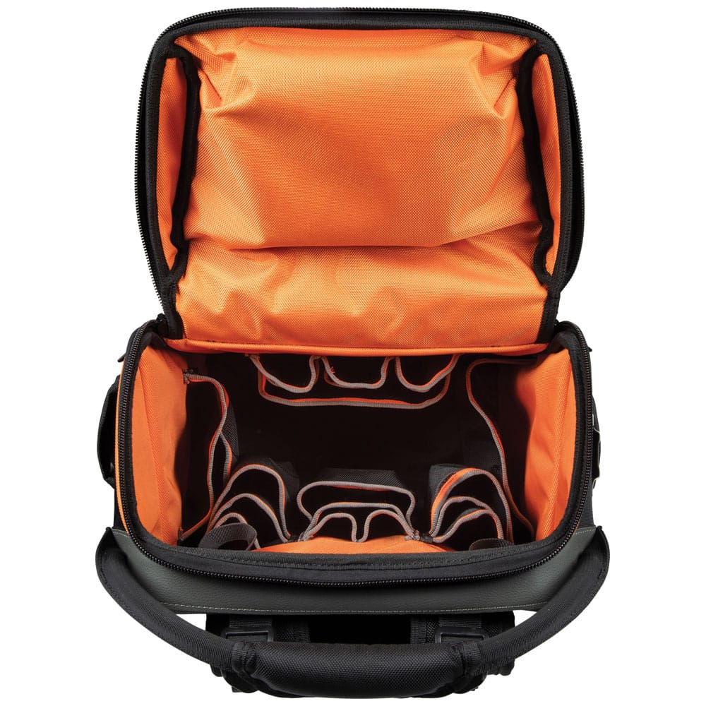 An overhead view looking into the fully unzipped main compartment of the tool backpack. The high-visibility orange interior features multiple tiered pockets for organized storage of hand tools, ensuring everything is easily accessible in low-light environments.