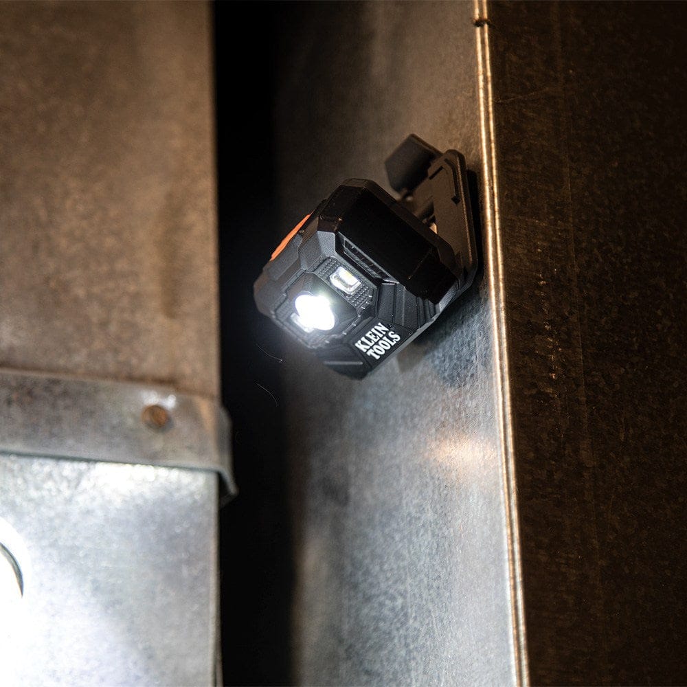 The headlamp used as a stationary work light, mounted magnetically to a vertical metal surface and illuminating a narrow space between equipment.