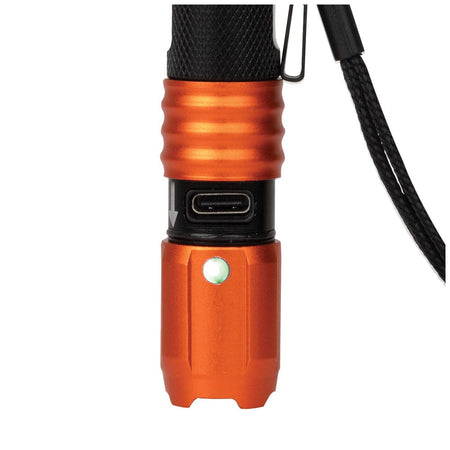 Close-up view of the flashlight with the orange protective collar slid down to reveal the integrated USB-C charging port and the battery life indicator glowing green to signal a full charge.