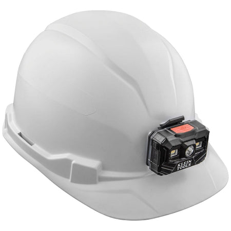 A side profile of the Klein Tools white professional work gear, showcasing the compact cap-style brim and the secure, low-profile attachment of the rechargeable LED headlamp to the patented front accessory mount.