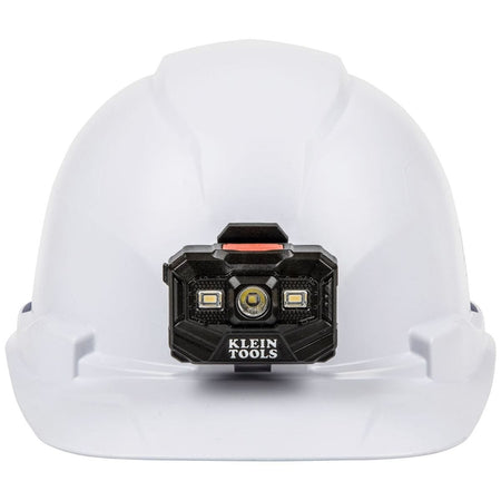 A front-facing view of the Klein Tools safety helmet, emphasizing the centered 300-lumen rechargeable LED headlamp and the protective cap-style brim designed for industrial and construction safety.