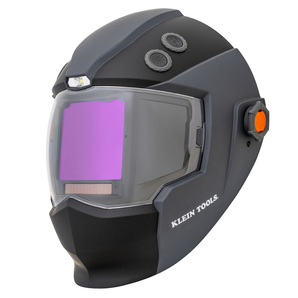 A studio view of the Klein Tools 60141 Phoenix Series panoramic welding helmet. The helmet features a professional black and gray high-impact shell with a large three-window panoramic lens and integrated top-mounted LED headlamp.