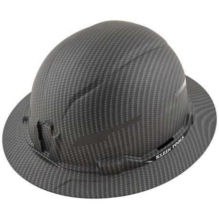 A perspective view of the Klein Tools 60345 premium KARBN™ pattern non-vented full brim hard hat, showcasing the modern hydro-dipped polymer film design and rugged PC/ABS composite shell for professional construction safety.