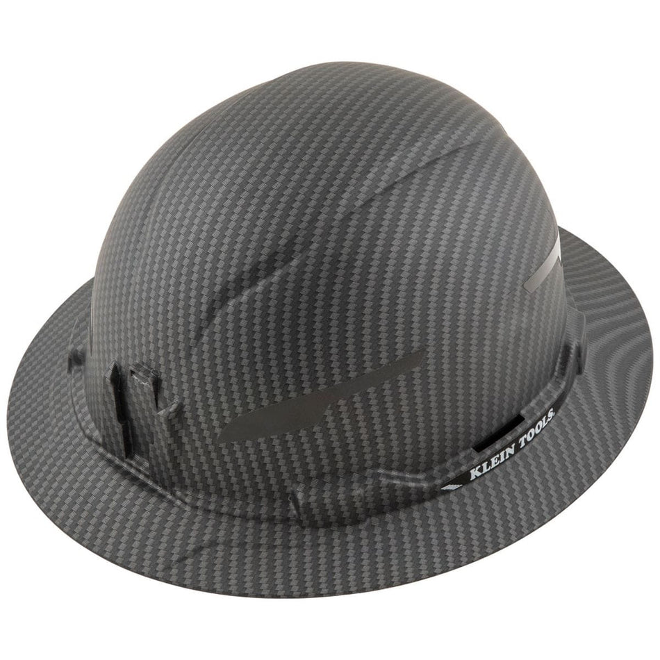 A perspective view of the Klein Tools 60345 premium KARBN™ pattern non-vented full brim hard hat, showcasing the modern hydro-dipped polymer film design and rugged PC/ABS composite shell for professional construction safety.