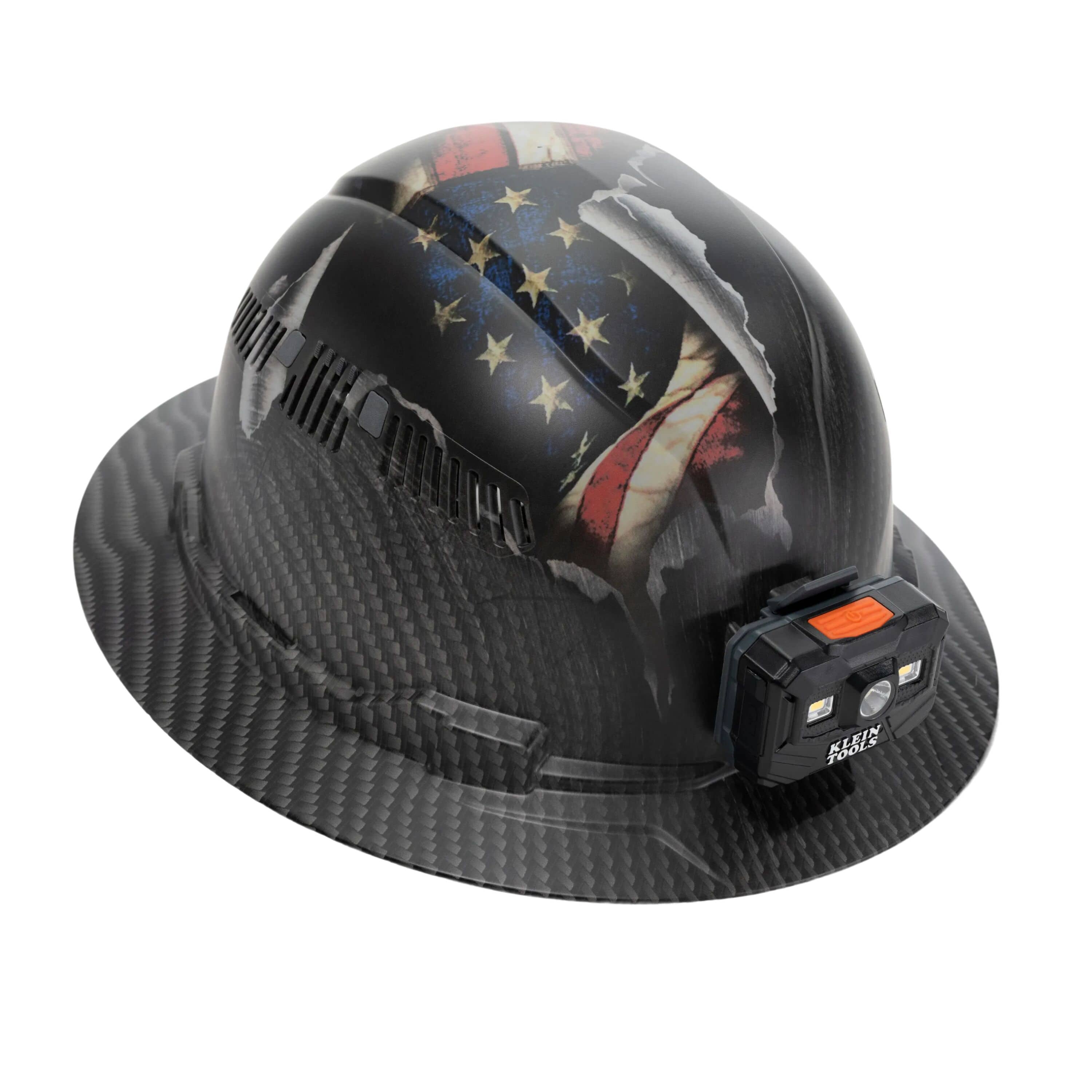 Perspective view of the Klein Tools 60347FS Class C vented full brim hard hat with hydro-dipped KARBN US Flag design and front-mounted rechargeable LED headlamp.