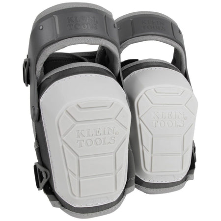 A pair of Klein Tools 60897 heavy-duty stabilizer knee pads shown from a front-facing perspective. The image highlights the large, white, non-marring shells with the Klein Tools logo and the protective gray hinged thigh straps.