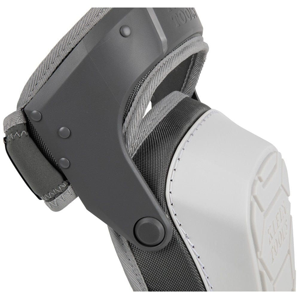 A close-up view of the side profile of the Klein Tools knee pad, showcasing the heavy-duty plastic rivets and the gray hinged thigh strap mechanism that allows for flexibility and comfort during movement on the jobsite.