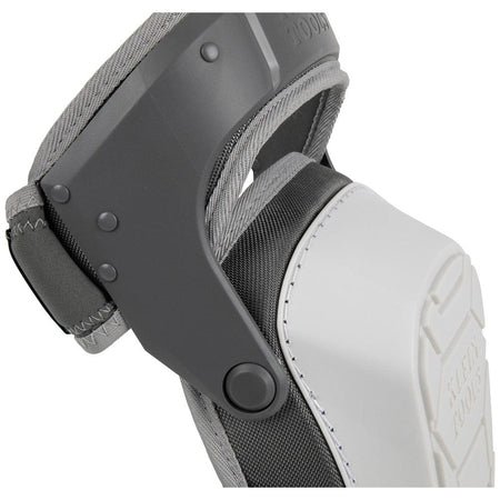 A close-up view of the side profile of the Klein Tools knee pad, showcasing the heavy-duty plastic rivets and the gray hinged thigh strap mechanism that allows for flexibility and comfort during movement on the jobsite.