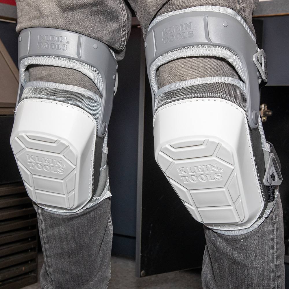 A low-angle view of the knee pads being worn, emphasizing the slip-resistant shell material that grips kneeling surfaces to enhance stability for tradespeople working on finished floors.
